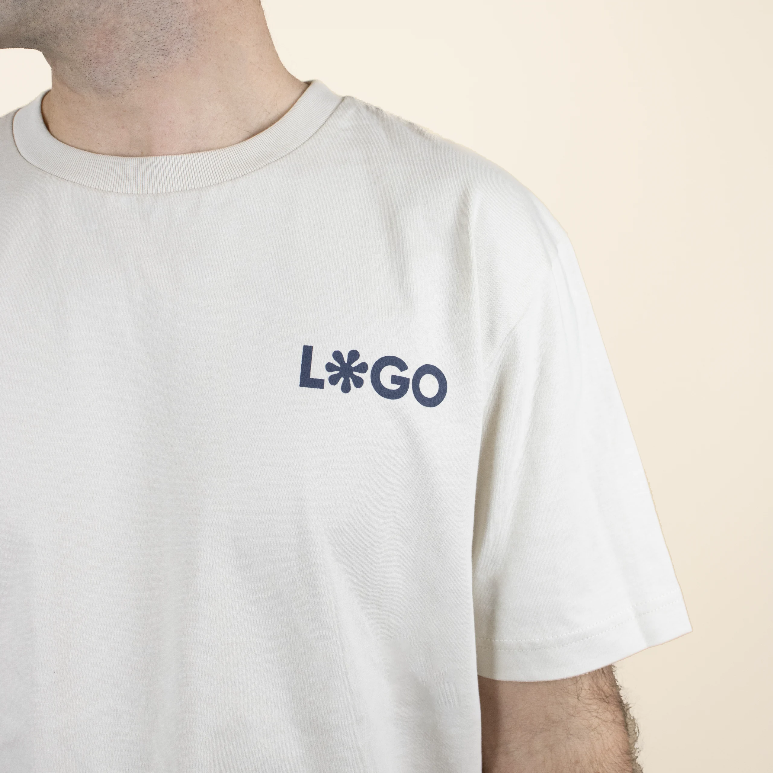 camiseta organica color beige logo frontal Camiseta orgánica color Beige con logro azul frontal chico