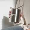 Taza take away con pajita color plateado personalizado logo blanco modelo chica con vaqueros