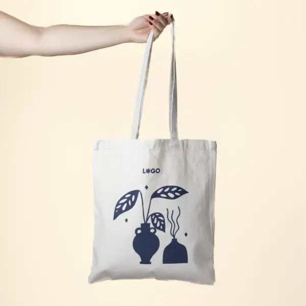 Mano sujetando una bolsa de algodón personalizada con logo azul
