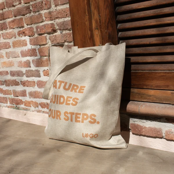 Bolsas de cáñamo personalizada con logo naranja apoyada en el suelo