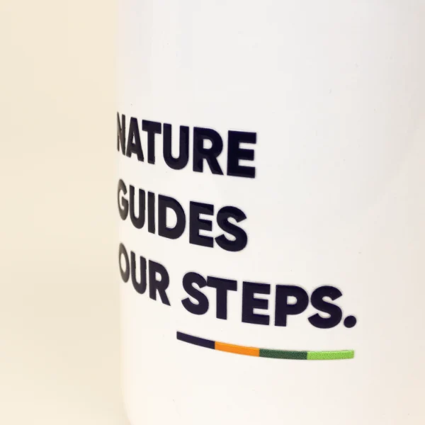 Taza Blanca personalizada con detalle de logo azul sobre fondo beige