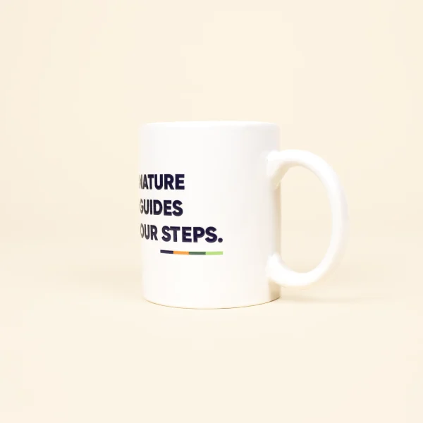 Taza Blanca personalizada con logo azul lateral sobre fondo beige