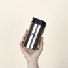 Taza termica plateada personalizada modelo mano fondo beige
