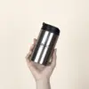 Taza termica plateada personalizada modelo mano fondo beige