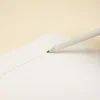 Lápiz de papel reciclado personalizado escribiendo en cuaderno blanco