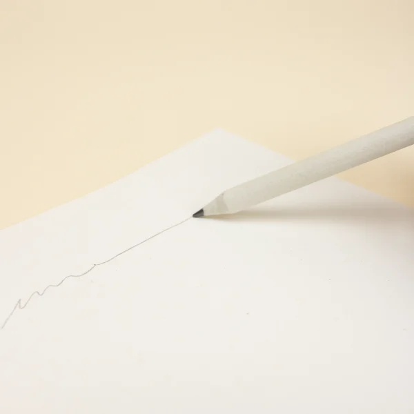 Lápiz de papel reciclado personalizado escribiendo en cuaderno blanco