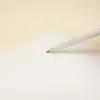 Lápiz de papel reciclado personalizado escribiendo en cuaderno blanco