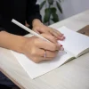 Lápiz de papel reciclado personalizado modelo mano chica escribiendo en cuaderno