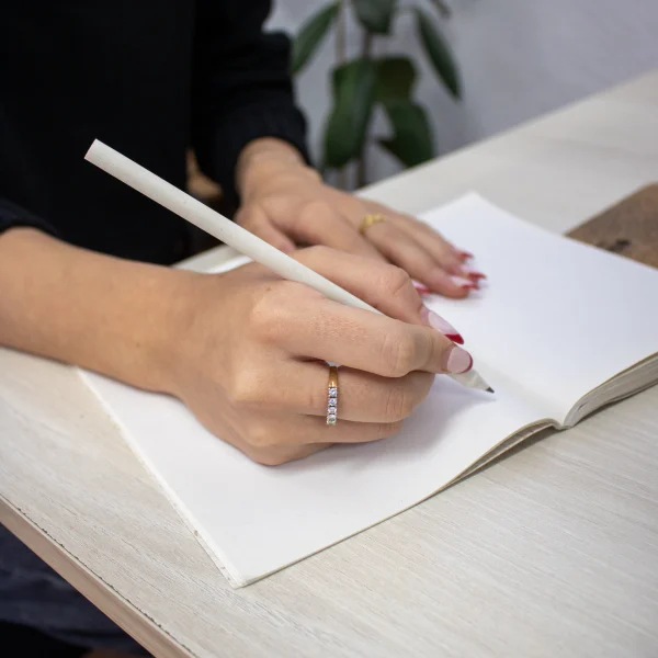 Lápiz de papel reciclado personalizado modelo mano chica escribiendo en cuaderno