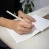 Lápiz de papel reciclado personalizado modelo mano chica escribiendo en cuaderno