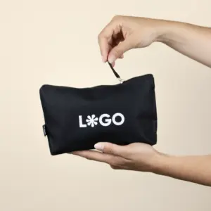 Neceser ecológico rpet negro personalizado con logo blanco modelo manos fondo beige
