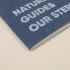 Cuaderno de grapa azul portada personalizada con texto blanco fondo beige