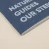 Cuaderno de grapa azul portada personalizada con texto blanco fondo beige