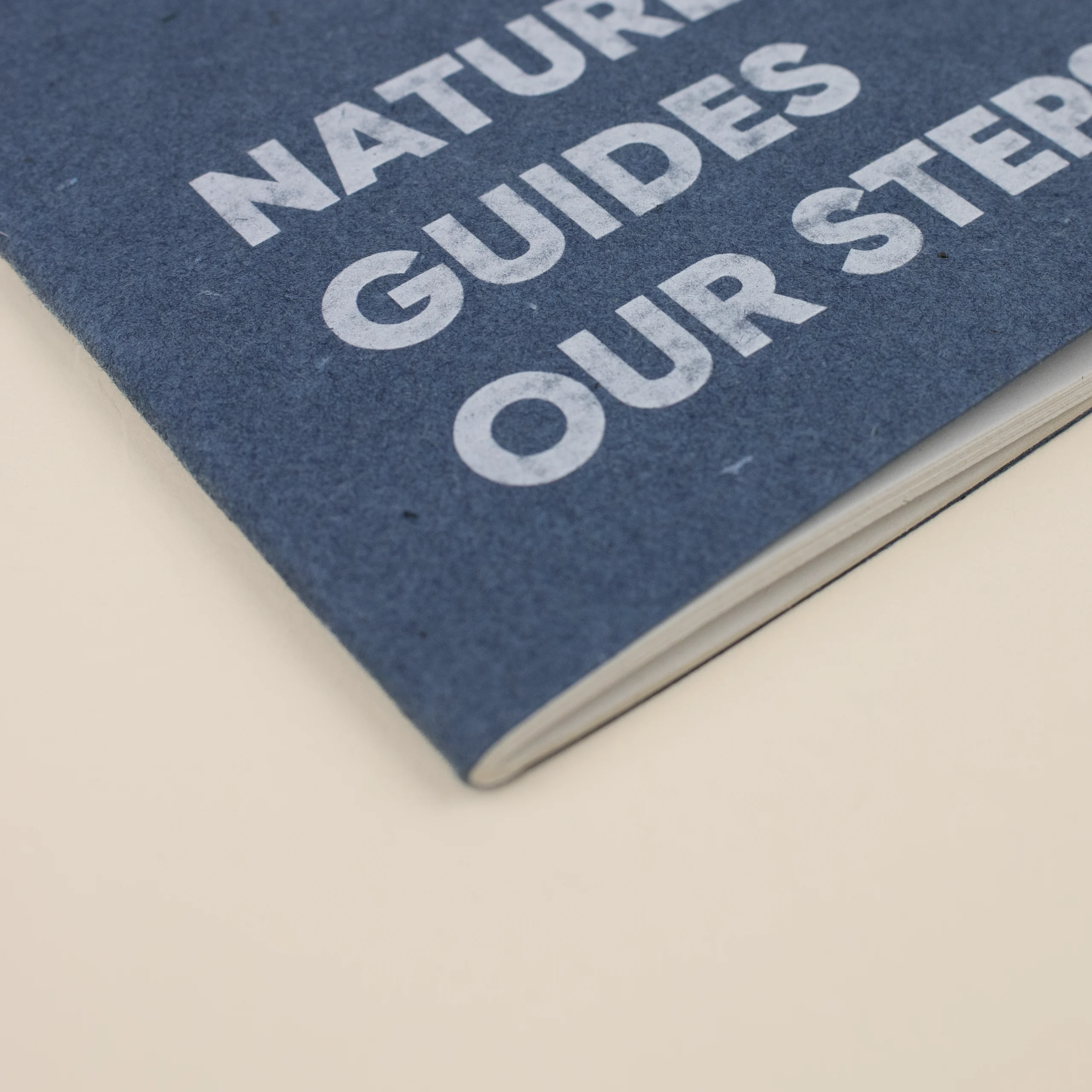 Cuaderno de grapa CRUDO JEANS Detalle Cuaderno de grapa azul portada personalizada con texto blanco fondo beige