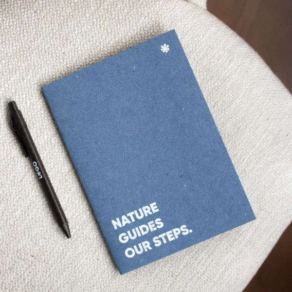 Cuaderno de grapa azul portada personalizada con texto blanco y bolígrafo