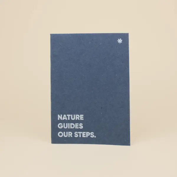 Cuaderno de grapa azul portada personalizada con texto blanco fondo beige