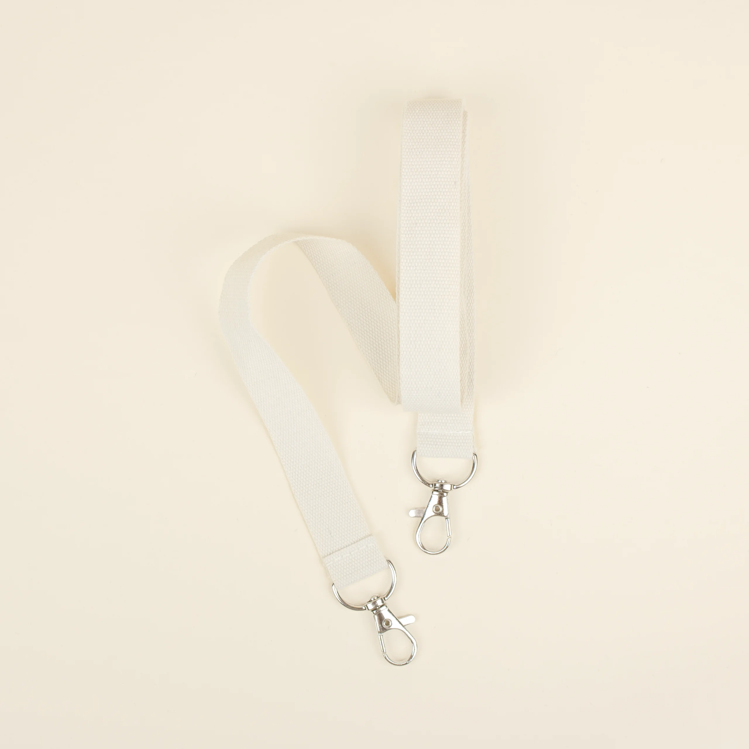 Lanyard sostenible doble mosquetón Lanyard sostenible doble mosquetón doblado fondo beige