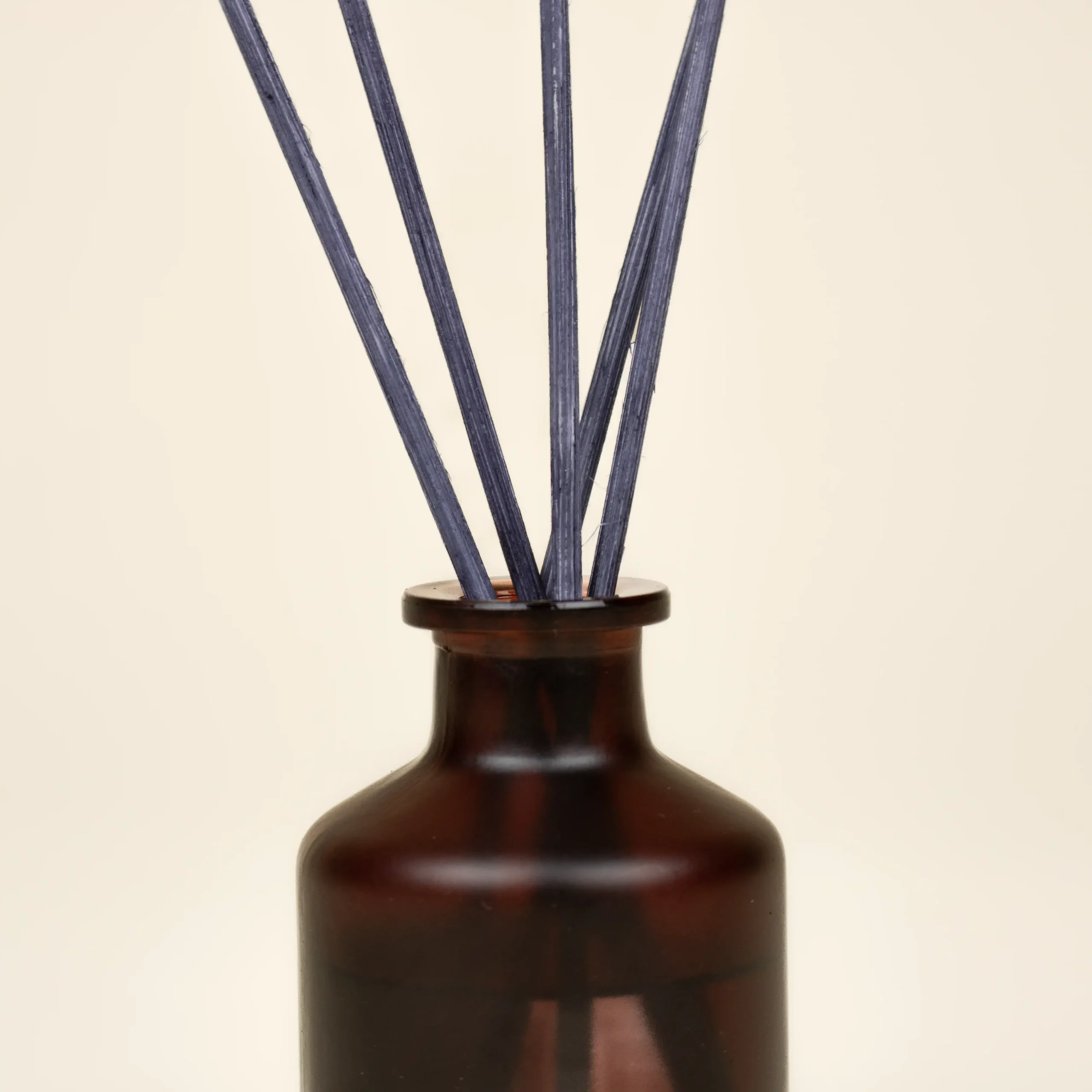 Ambientador mikado personalizado MILKE Detalle Ambientador mikado personalizado de vidrio marrón fondo beige