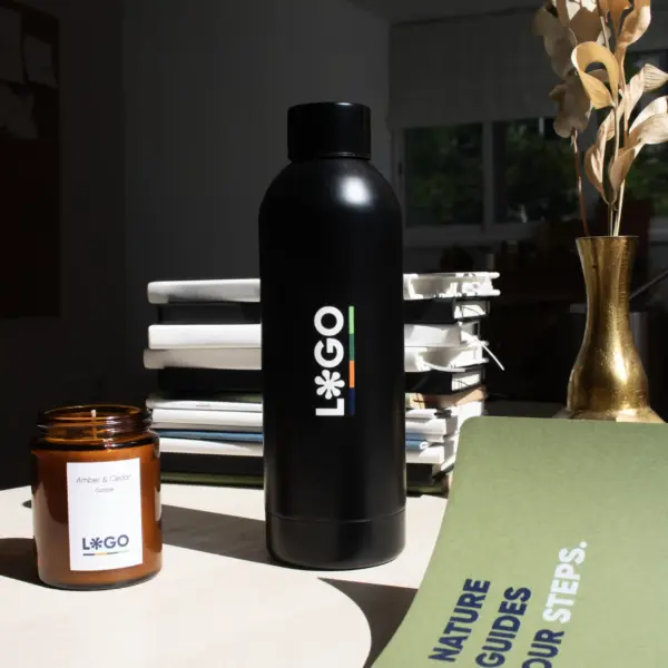 Botella térmica color negro personalizada con logo blanco cuaderno verde y vela