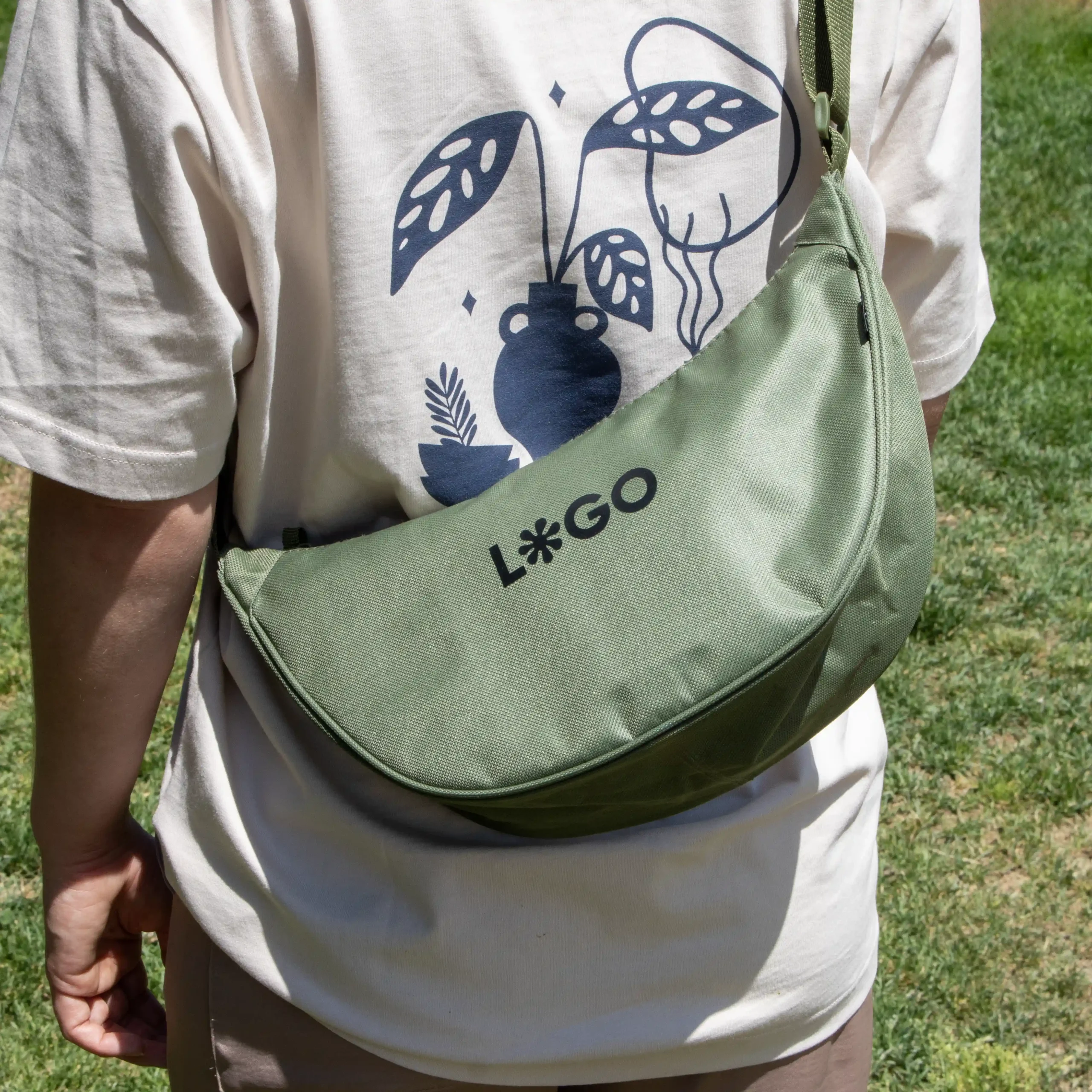 Sac banane NOON personnalisé Lifestyle Green Sac banane vert personnalisé avec logo fille sur fond de parc modèle