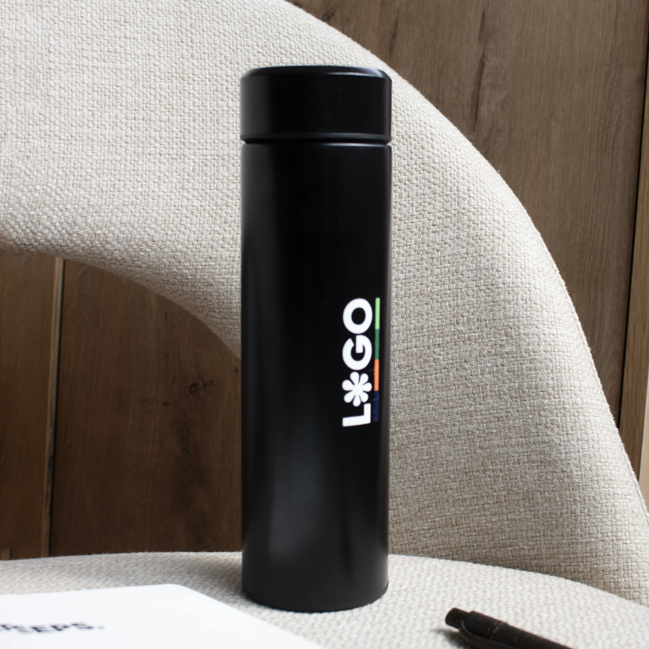 Thermos en acier inoxydable PISA Noir thermos en acier inoxydable personnalisée logo noir blanc soutenue par une chaise grise