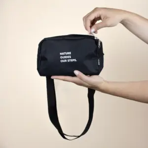 Riñonera negra rectangular personalizada manos fondo beige