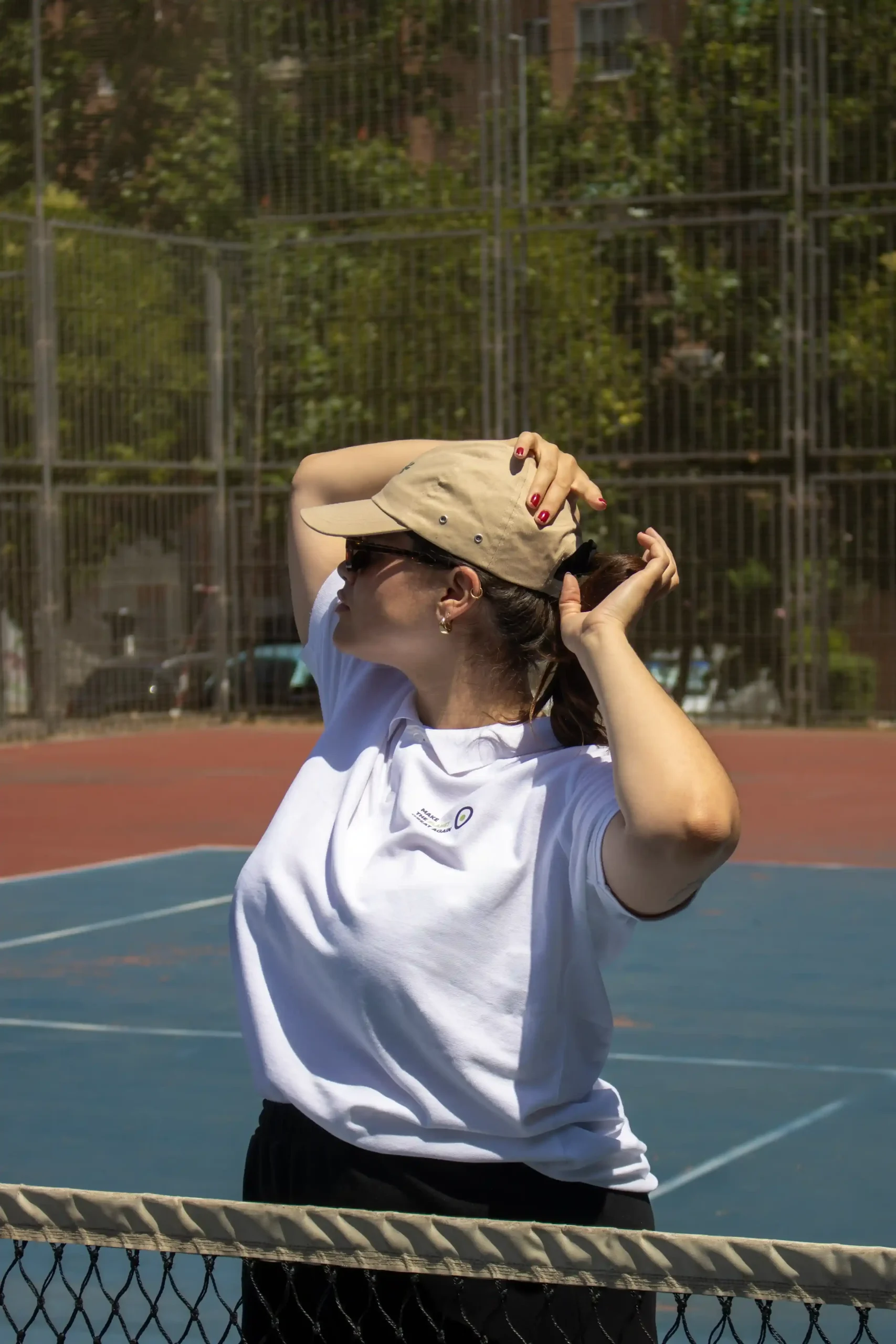 Casquette beige personnalisée modèle fille sur court de tennis.