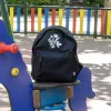 Mochila personalizada para niños color negro con logo blanco columpio parque infantil