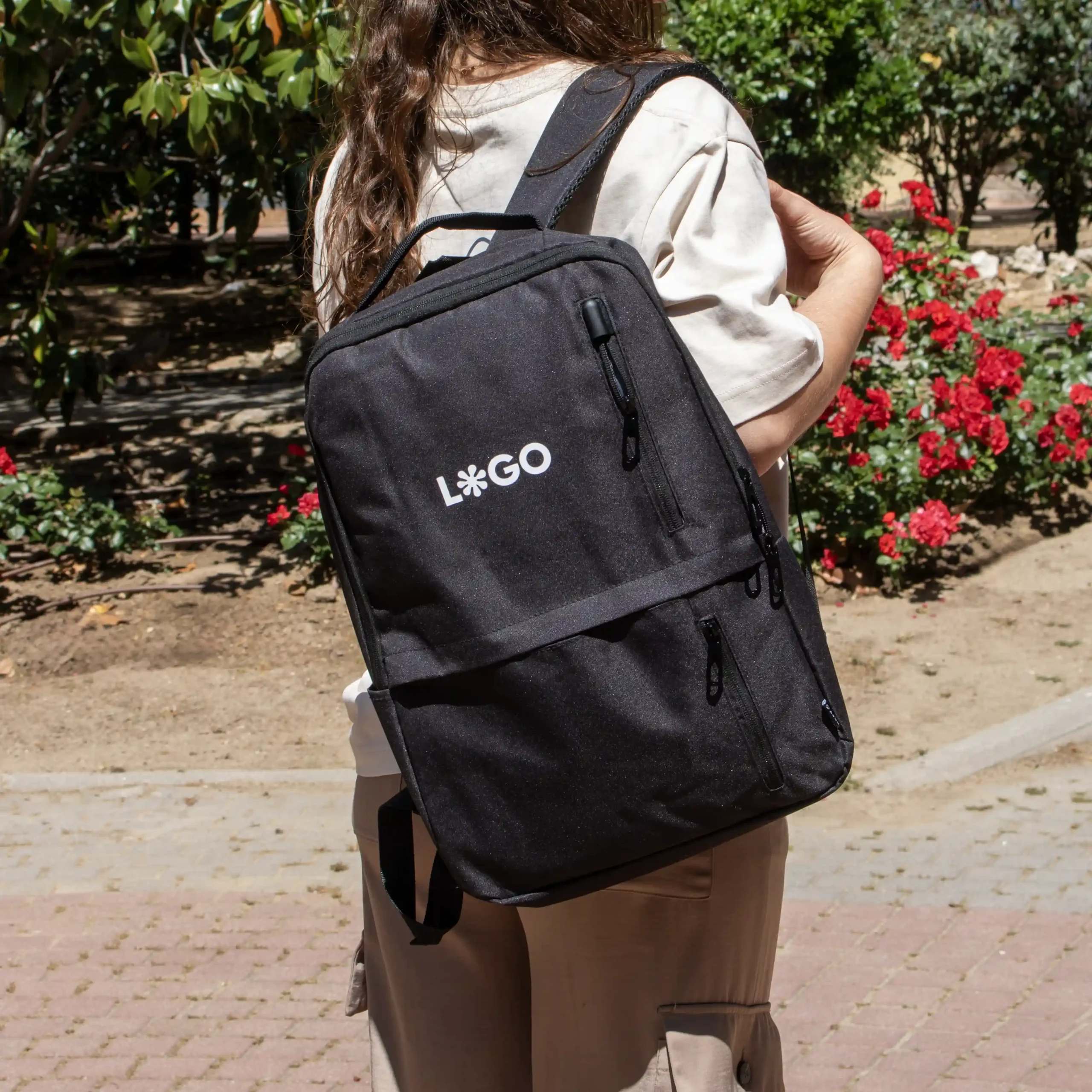 Mochila de empresa DUPPIA Negra Lifestyle Mochila de empresa personalizada negra con logo blanco modelo chica en la calle