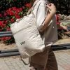 Mochila de algodón personalizada beige con logo negro modelo chica en la calle