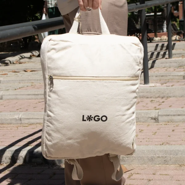 Mochila de algodón personalizada beige con logo negro modelo mano calle
