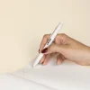 Mano sujetando bolígrafo de caña de trigo blanco personalizado con logo