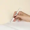 Mano sujetando bolígrafo de caña de trigo blanco personalizado con logo