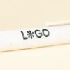 bolígrafo de caña de trigo blanco personalizado con logo sobre fondo beige