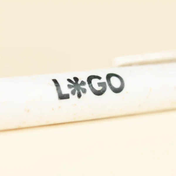 bolígrafo de caña de trigo blanco personalizado con logo sobre fondo beige