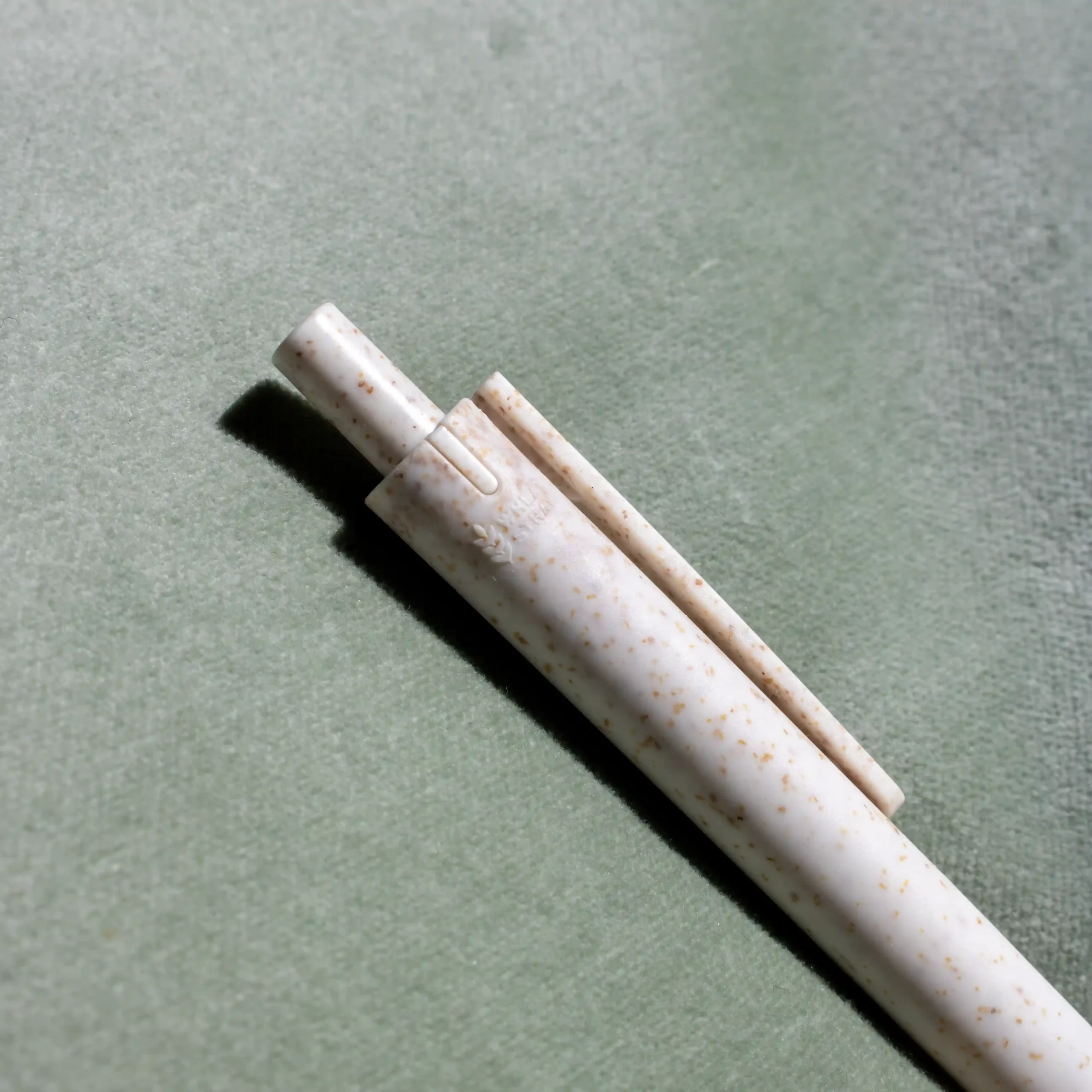 Bolígrafo trigo GLUT Beige Pulsador bolígrafo de caña de trigo blanco sobre fondo verde