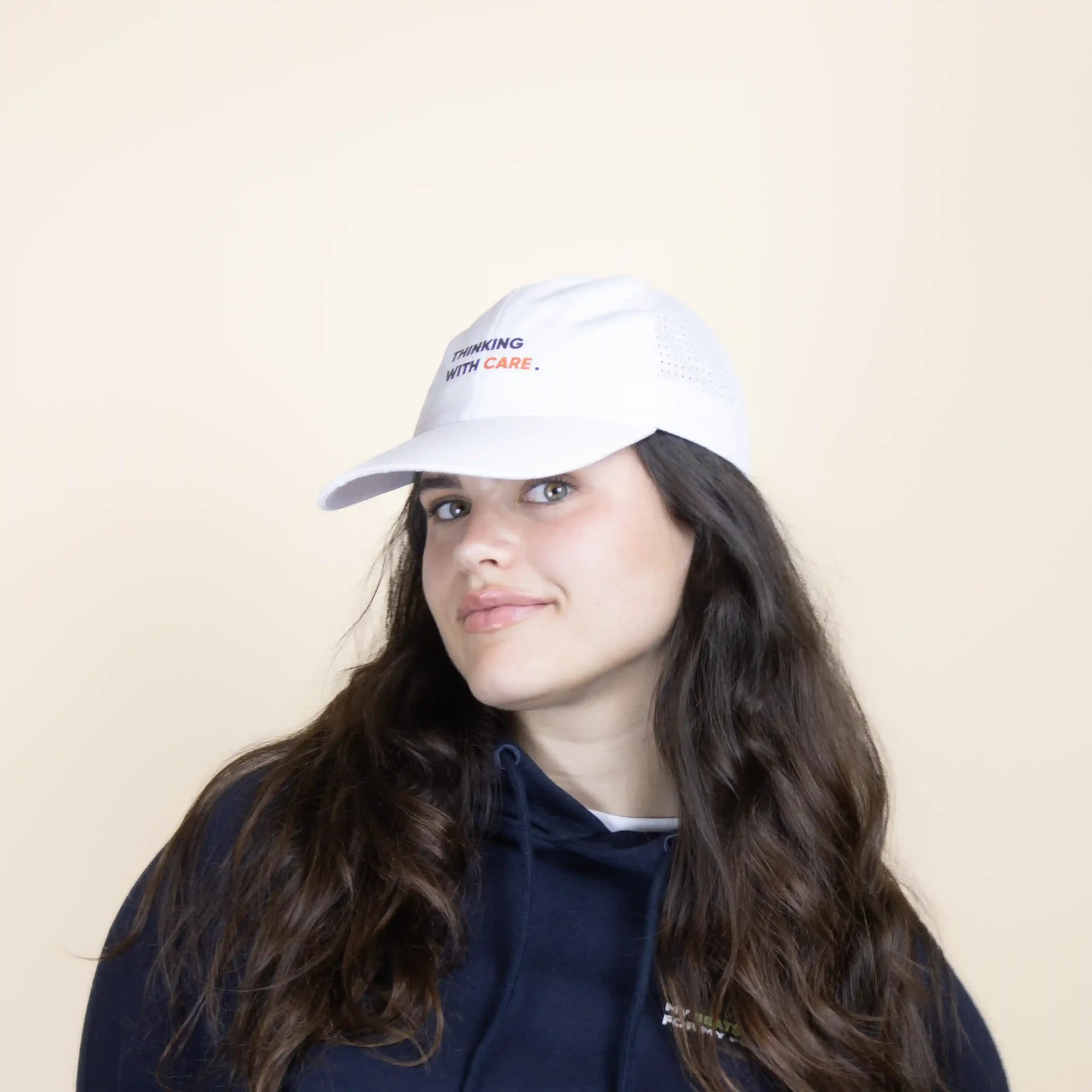 Casquette blanche personnalisée, modèle tête de femme de face sur fond beige.