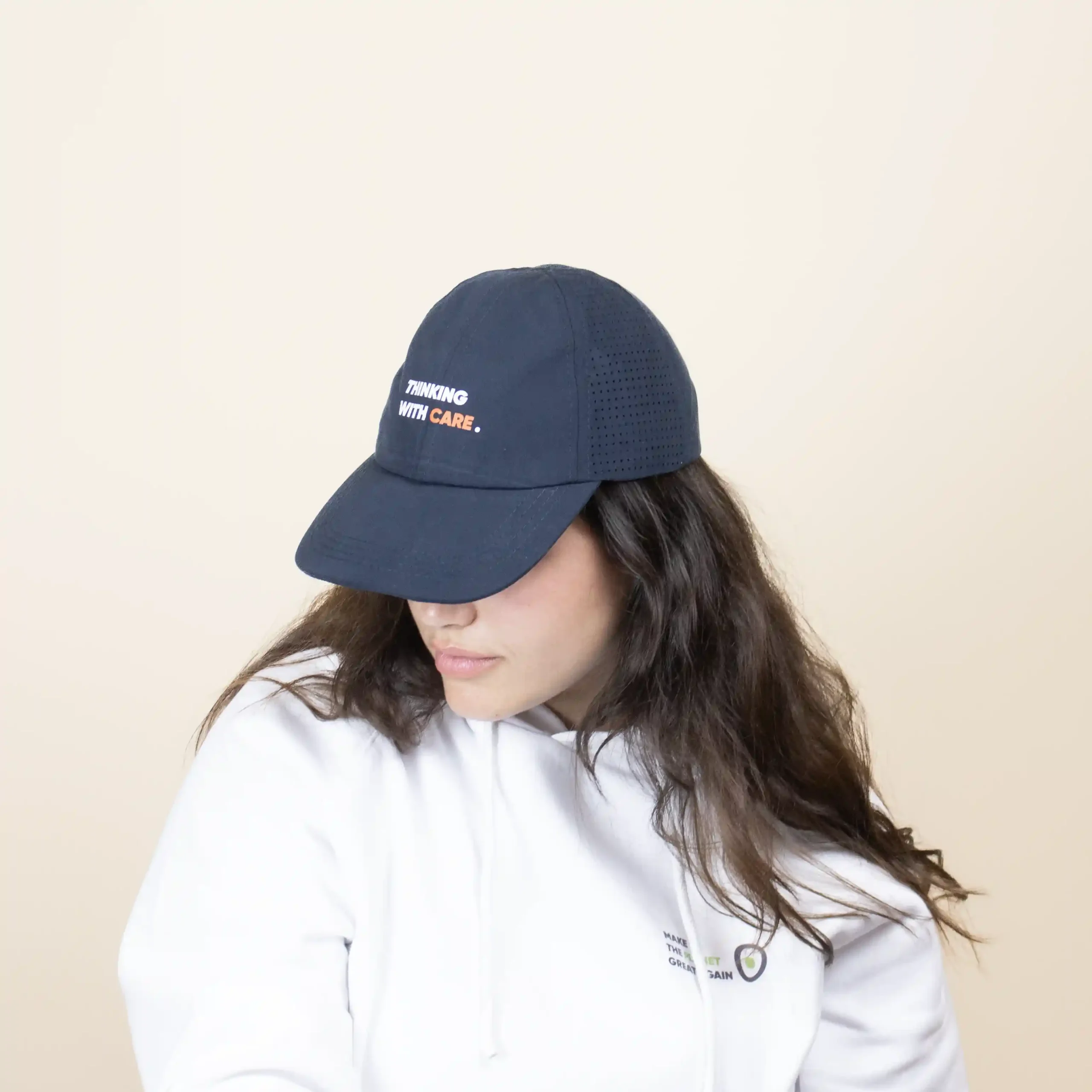 Casquette bleue personnalisée, modèle tête de femme de face sur fond beige.