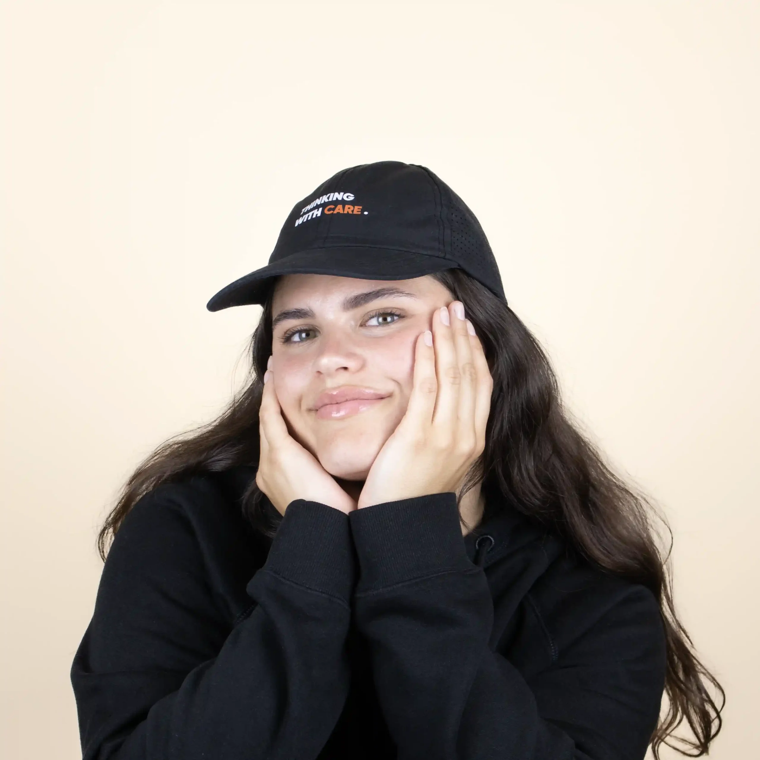 Casquette noire personnalisée, modèle tête de femme de face sur fond beige.