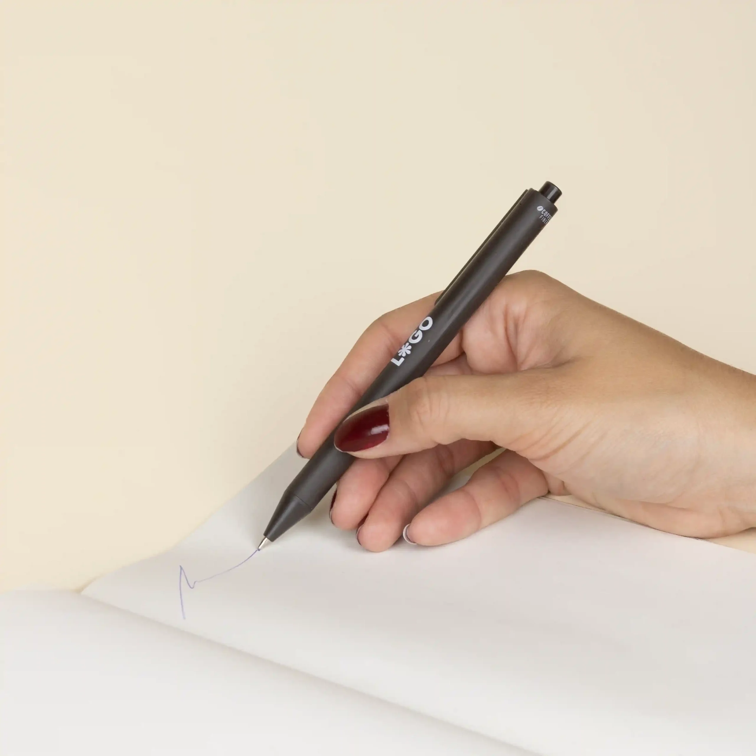 Bolígrafo fibra de cafe KOHV Mano escribiendo en cuaderno con bolígrafo de fibra de cafe personalizado con logo blanco