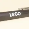 Cuerpo de bolígrafo marrón de fibra de cafe personalizado con logo blanco sobre fondo beige