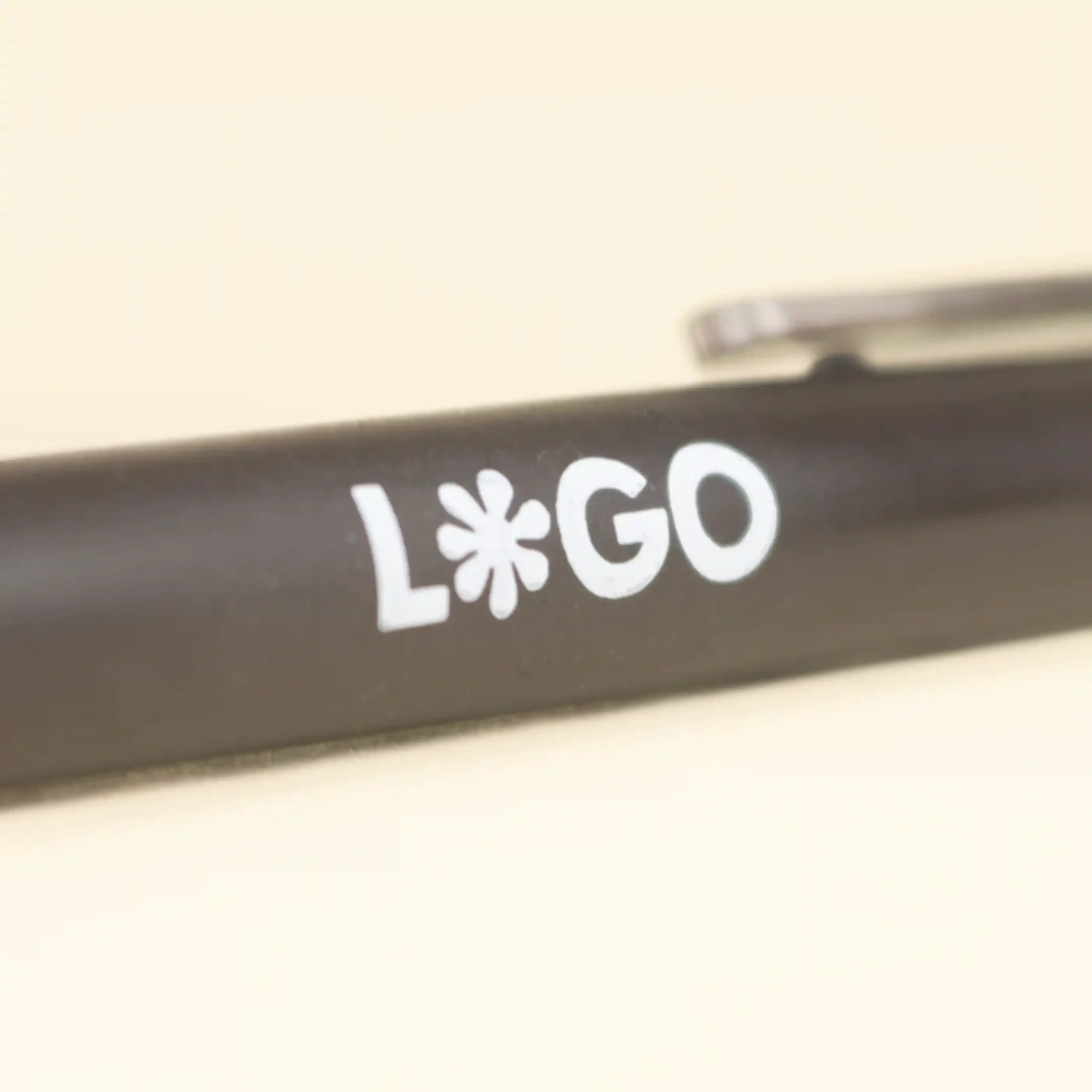 Bolígrafo fibra de cafe KOHV Logo Cuerpo de bolígrafo marrón de fibra de cafe personalizado con logo blanco sobre fondo beige