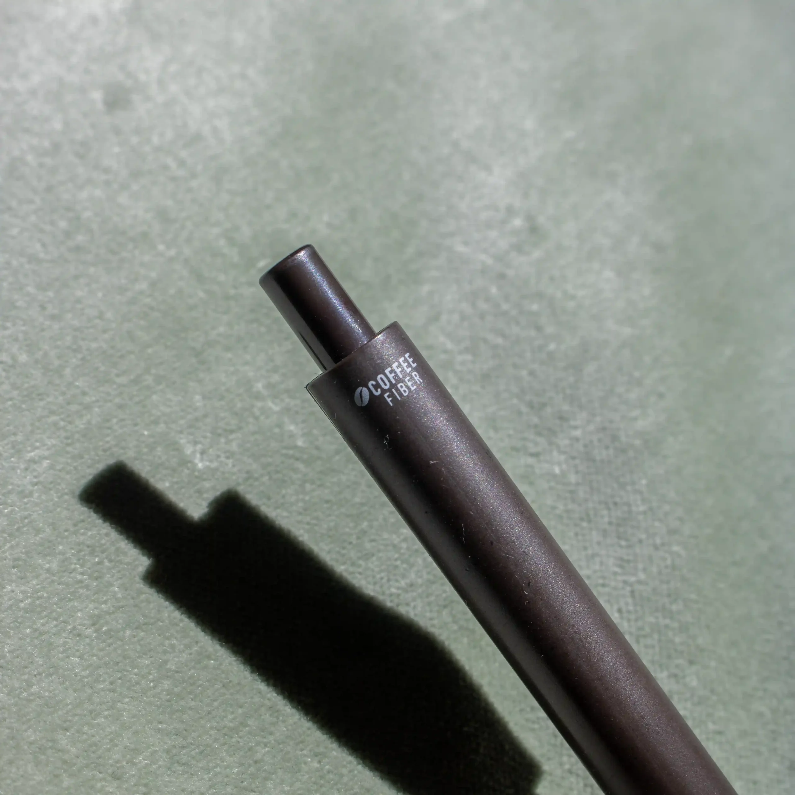 Brown coffee pen on a green background