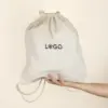 Mochila cuerdas personalizada tipo saco color beige con logo negro modelo mano fondo beige