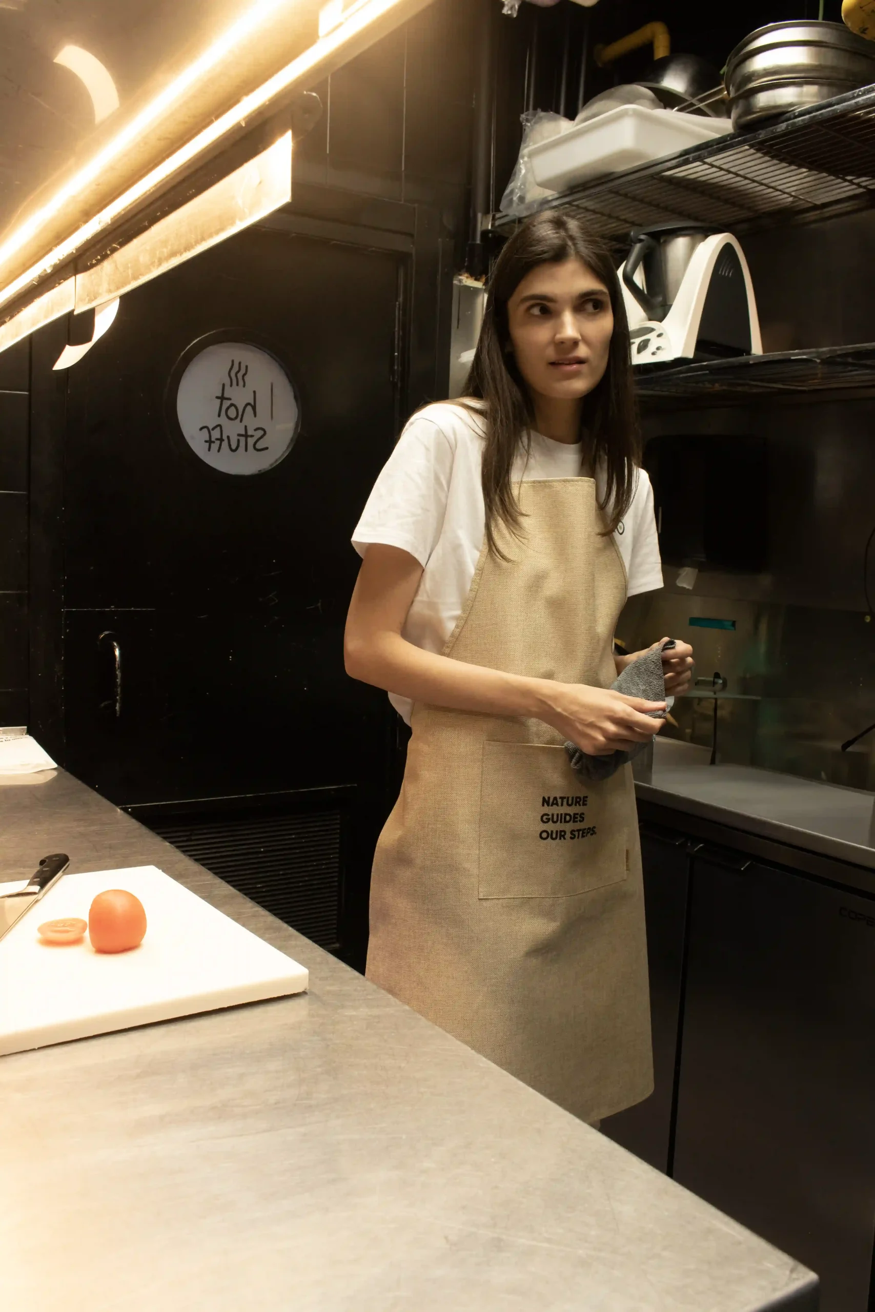 Tablier écologique modèle femme dans la cuisine d'un restaurant