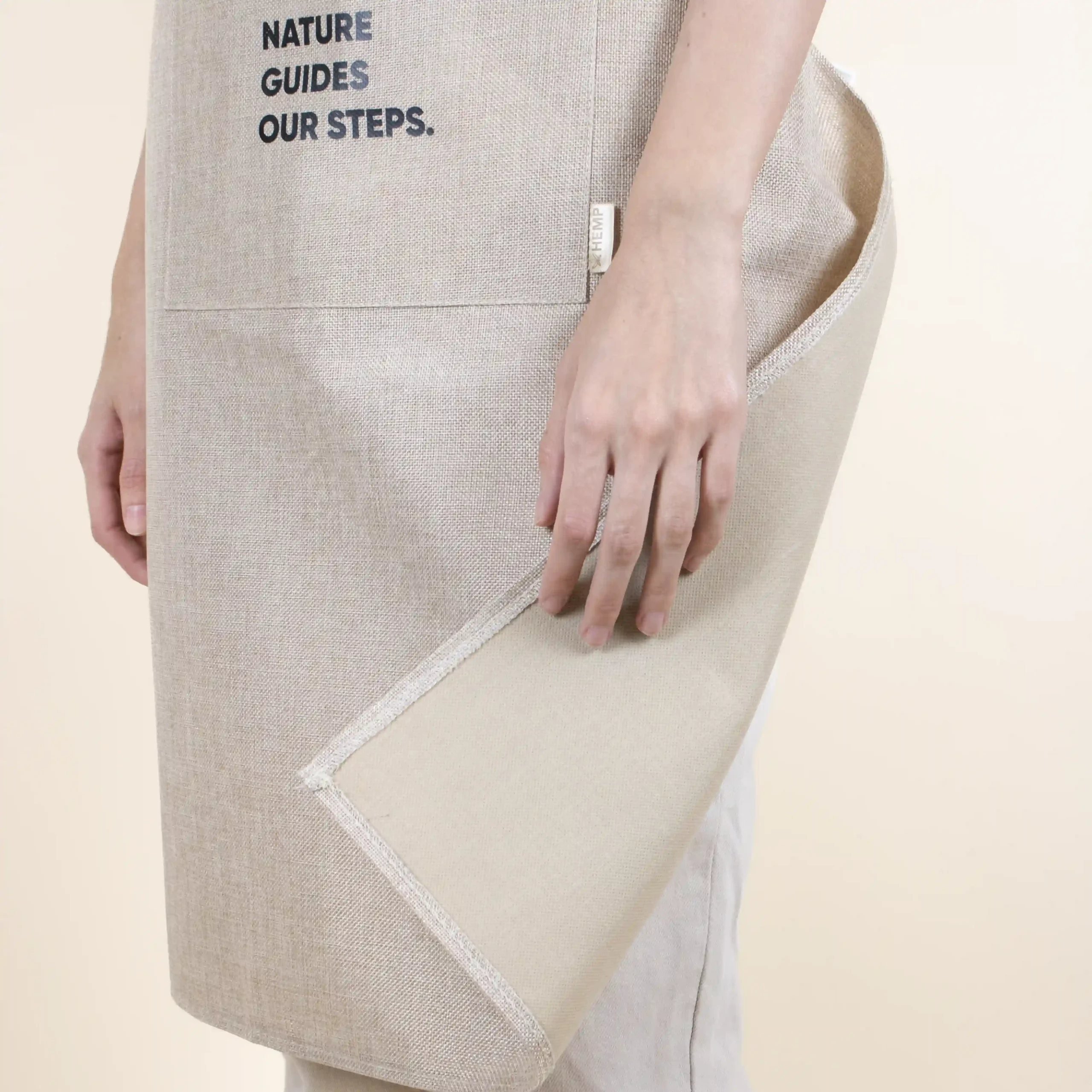Tablier écologique beige modèle fille détail tissu fond beige