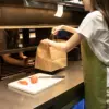 Delantal ecológico verde modelo chica en cocina de restaurante