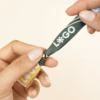 Manos sobre fondo beige mostrando una pulsera reciclada en rPET personalizada con logo a todo color