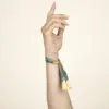 Mano sobre fondo beige llevando una pulsera reciclada en rPET personalizada con logo a todo color