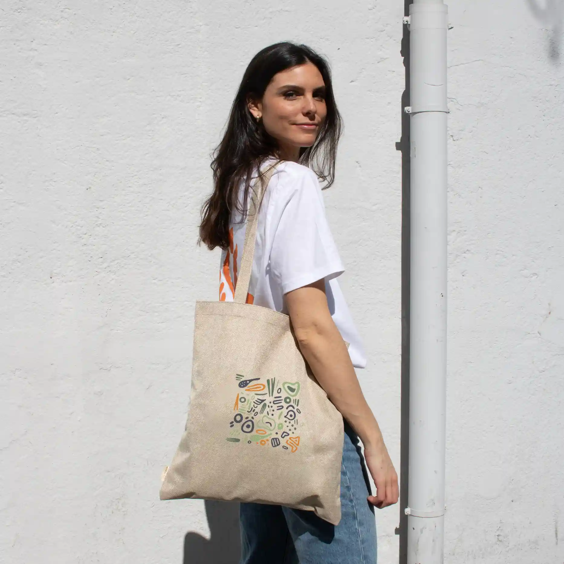 Bolsas de cáñamo HEBRA Lifestyle Chica paseando en la calle con bolsa de cáñamo personalizada con logo de colores